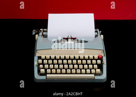 Machine à écrire manuelle avec blank livre blanc sur fond rouge et noir Banque D'Images