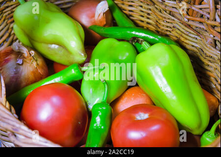 Les légumes frais biologiques dans le panier en osier. Poivron, tomate, piment, oignon, carotte. Banque D'Images