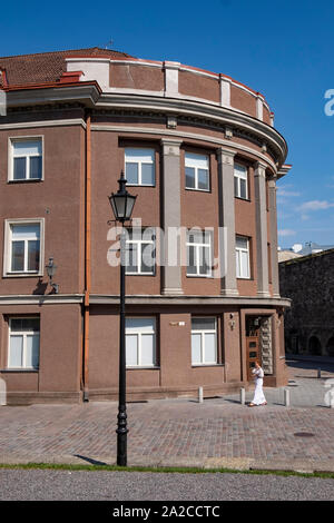 Femme marche sur le trottoir devant l'ancien bâtiment dans la rue Harju, Tallinn, Estonie Banque D'Images