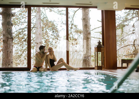 Loving couple dans le centre de spa par piscine Banque D'Images