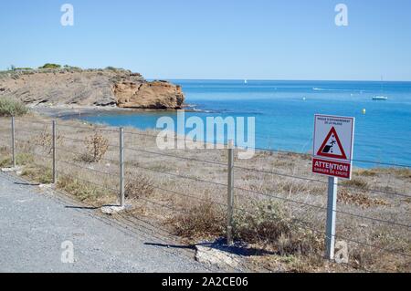 Un panneau d'avertissement sur une falaise du Cap d'Agde, France Banque D'Images