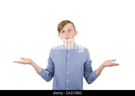 Perplexe teenage boy propagation les bras tendus, les mains d'équilibrage à la gestuelle et à l'appareil photo, a deux options au choix à droite ou à gauche, décision conce Banque D'Images