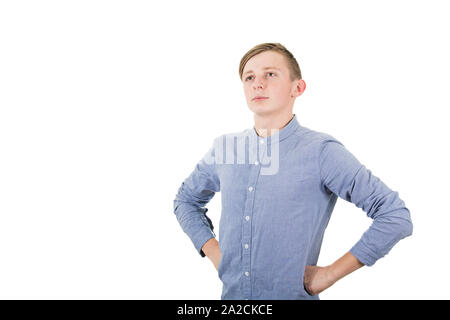 Brave garçon adolescent les mains sur les hanches à la confiance de côté isolé sur fond blanc. Banque D'Images