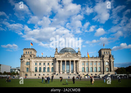 Berlin, Allemagne. 09Th Oct, 2019. Les gens sont debout sur la prairie en face du bâtiment du Reichstag. Credit : Arne Immanuel Bänsch/dpa/Alamy Live News Banque D'Images