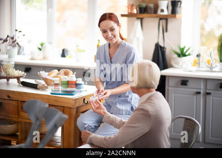 Femme aux cheveux gris et prendre les pilules d'aidant naturel Banque D'Images