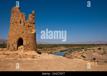Ancienne tour de guet construite en briques en terre cuite située le long des rives du Draa au Maroc Banque D'Images