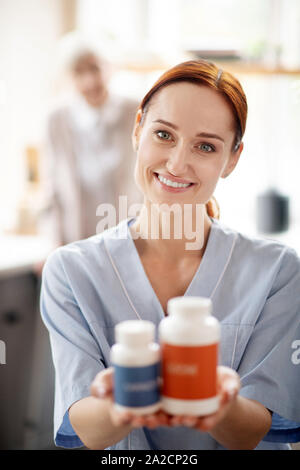 Caregiver holding Vitamines et suppléments pour des patients Banque D'Images