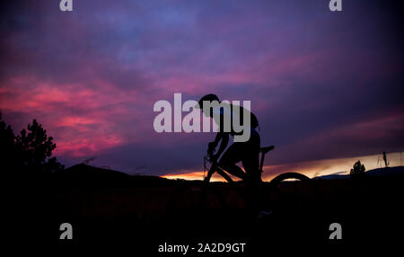 Une femme en vélo de montagne au coucher du soleil près de Missoula, Montana. Banque D'Images