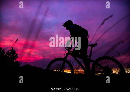 Une femme en vélo de montagne pendant le coucher du soleil près de Missoula, Montana Banque D'Images