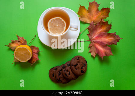 Le thé. Le thé vert. Tisane. Feuille de menthe. Plateau avec saveur de pomme. Du thé dans une tasse en verre avec apple les fleurs et les feuilles de thé séchées tranches de lime. herbes plateau et m Banque D'Images