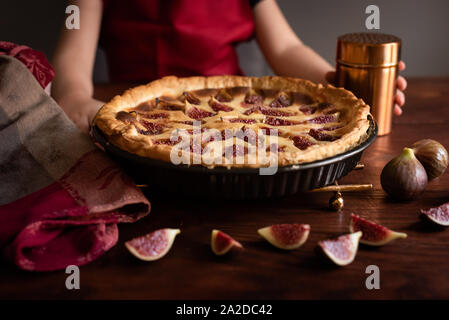 Close-up of girl holding des fig tart fond sombre Banque D'Images