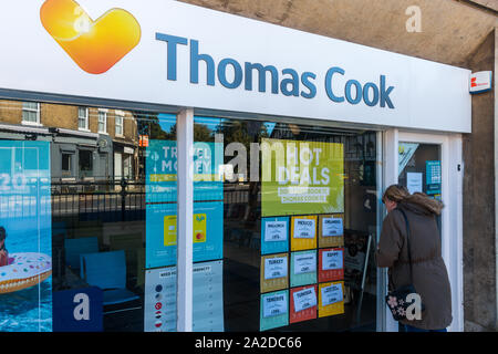 Ancien Thomas Cook Travel store, Biggleswade High Street, malheureuse femme à la clientèle dans le cadre de fenêtre fermé boutique. Banque D'Images