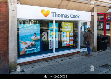 Ancien Thomas Cook Travel store, Biggleswade High Street, malheureuse femme à la clientèle dans le cadre de fenêtre fermé boutique. Banque D'Images