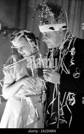 Prinzenpaar das der Fastnacht à Mayence, Martin Ohaus und Hildegard Kühne im Jahre 1938 bei einem Glas Sekt, Abendempfang auf einem zum hundertjährigen Jubiläum des Mainzer Carneval Verein (MCV). Les Altesses Royales de carnaval à Mayence en 1938, à l'occasion du 100e anniversaire de l'association carnaval locales leader, buvant un verre de vin mousseux. Banque D'Images