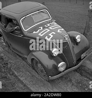 Eifel quält Ford Ein sich bei einer Autorallye durch ein Schlammloch, Deutschland 1930 er Jahre. Un modèle Ford Eifel aux prises avec un trou de boue sur une voiture rallye, Allemagne 1930. Banque D'Images