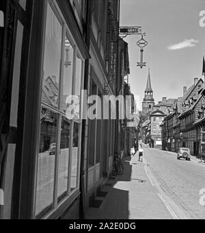 Geschäftsstraße à Hildesheim mit Blick auf den Turm der St. Michaeliskirche, Deutschland 1930er Jahre. Shopping Mall à Hildeheim avec vue sur le beffroi de l'église Saint-Michel, l'Allemagne des années 1930. Banque D'Images