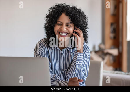 Femme entrepreneur rire à parler avec un client sur son portable Banque D'Images