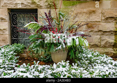 Maison de vacances Semoir avec des branches de Pins à l'extérieur d'une maison dans un jardin couvert de neige en hiver Banque D'Images