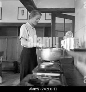 Une Bohnensuppe Köchin bereitet die in der Küche der Adolf-Hitler-Jugendherberge à Berchtesgaden, Deutschland 1930 er Jahre. Une femme cuisinière préparer une soupe de haricots verts à la cuisine de l'Hotel d'Adolf Hitler à Berchtesgaden, Allemagne 1930. Banque D'Images