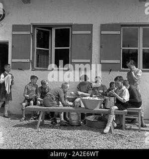 Helfen der jungen der Herbergsmutter Adolf-Hitler-Kartoffelnschälen à Berchtesgaden Gästehaus beim, Deutschland 1930 er Jahre. Les garçons d'aider le directeur de l'auberge à peler l'auberge de jeunesse d'Adolf Hitler à Berchtesgaden, Allemagne 1930. Banque D'Images