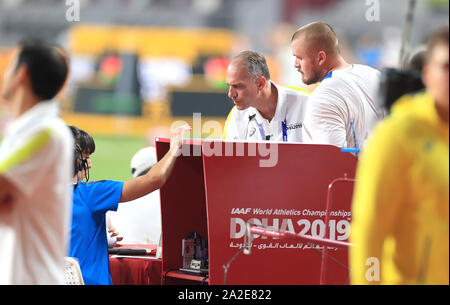 La société britannique Nick Miller (à droite) parle à un fonctionnaire de l'une de ses mesures dans le lancer du marteau hommes durant six jour final de la es Championnats du monde à la Khalifa International Stadium, Doha, Qatar. Banque D'Images