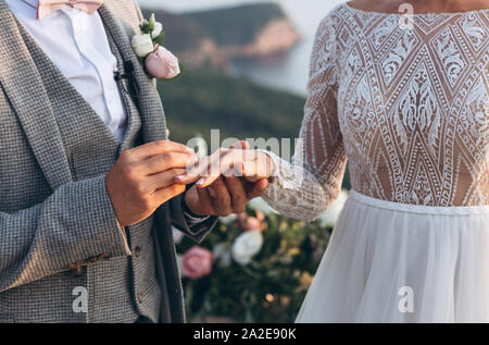 Le fiancé ou mari met l'anneau sur l'épouse ou la femme de la cérémonie de mariage. L'événement de mariage. Banque D'Images
