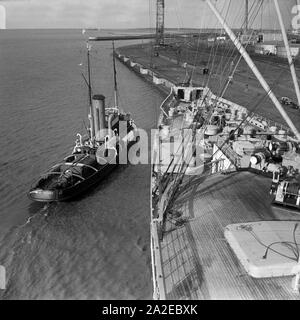 Schlepper aus das deutsche Passagierschiff 'Europa' dans die Werft à Bremerhaven, Allemagne Allemagne Années 1930 er Jahre. Remorqueurs tirant le navire à passagers allemand 'Europa' à l'arsenal à Bremerhaven, Allemagne 1930. Banque D'Images