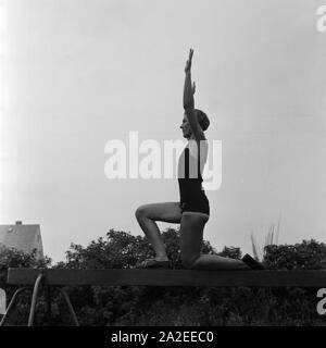 Eine Frau bei einer Übung suis Schwebebalken dans der Logau Musterschule für Frauenturnen à Hannover, Deutschland 1930er Jahre. Une femme faisant un exercice à la poutre à l'école des femmes de Logau gymnastics à Hanovre, Allemagne 1930. Banque D'Images