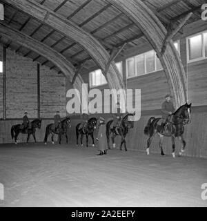 SA Männer üben im Schritt Reiten in der Reithalle der Reichs Führer Reiter Schule à Berlin Zehlendorf, Deutschland 1930 er Jahre. Les hommes exerçant sa marche équitation au manège de l'équitation l'école à Berlin Zehlendorf, Allemagne 1930. Banque D'Images