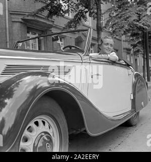 Für den Werbefoto Personenkraftwagen Ford mit einer jungen Frau Eifel am Steuer, Deutschland 1935. Photo commerciale pour le passager car Ford Eifel avec une jeune femme, Allemagne 1935. Banque D'Images