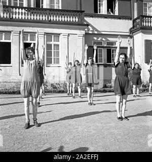 Bei der Frauen Morgengymnastik Kuraufenthalts während eines im Mutter und Genre Heim dans Tabarz, Thüringer Wald, 1930er Jahre. Les femmes faisant des exercices le matin à une mère et l'enfant accueil de loisirs à Vesser, Thuringe. Années 1930. Banque D'Images