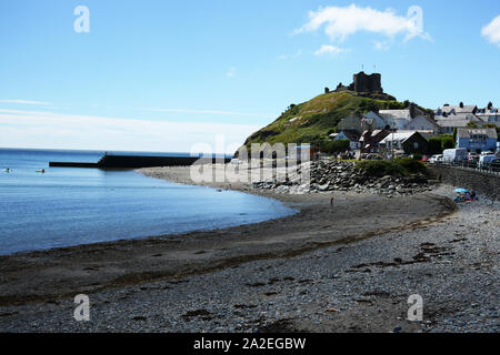 Vue sur la plage avec le château de Criccieth sur la colline au loin. Banque D'Images