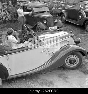 Für den Werbefoto Personenkraftwagen Ford Eifel mit einem Paar bei ihr den idealen er dem Parkplatz zeigt, Deutschland 1935. Photo commerciale pour le passager car Ford Eifel avec couple où il montre sa le meilleur parking, Allemagne 1935. Banque D'Images