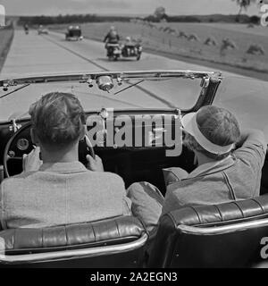 Mit dem Ford V8 Cabrio unterwegs auf der Autobahn Berlin Stettin, Deutschland 1930 er Jahre. Sur la route entre Berlin et Stettin avec la Ford V8 décapotable, Allemagne 1930. Banque D'Images