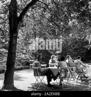 Männer und Frauen un Außengastronomie sitzen und Tischen bei Triberg im Schwarzwald, Deutschland 1930 er Jahre. Les hommes et les femmes assis sur les tables d'une gastronomie plein air près de Triberg en Forêt-Noire, Allemagne 1930. Banque D'Images