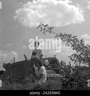 Ein Mann und eine Frau bei einer Rast vor ihrem Cabrio, Deutschland 1930 er Jahre. Un homme et une femme se reposant devant leur décapotable, Allemagne 1930. Banque D'Images