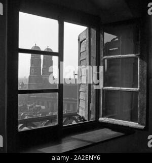 Blick durch ein geöffnetes Fenster auf die Frauenkirche à München, Deutschland 1930er Jahre. Vue à travers une fenêtre ouverte à Munich de l'église Frauenkirche, l'Allemagne des années 1930. Banque D'Images