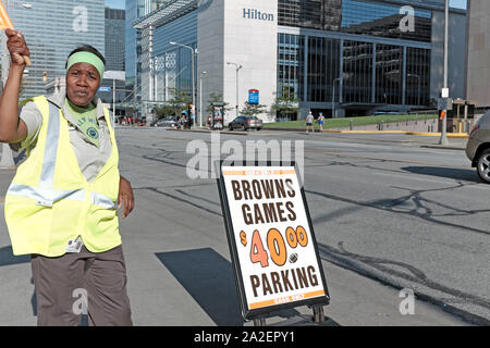 Cleveland Browns game day préposé au stationnement sur l'Avenue du Lac vagues de personnes sur le dollar 40,00 stationnement en centre-ville de Cleveland, Ohio, USA. Banque D'Images