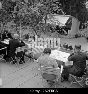 Kurgäste sitzenauf mit Terrasse und dem Kurorcher hören à Wildbad im Schwarzwald zu, Deutschland 1930 er Jahre. Les curistes assis sur une terrasse et écouter de la musique de l'orchestre à Wildbad Spa en Forêt-Noire, Allemagne 1930. Banque D'Images