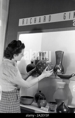 Eine der Leipziger Frühjahrsmesse Besucherin vor einem Stand der Porzellanmanufaktur Richard Ginori, Deutschland 1941. Un visiteur de la Leipziger Frühjahrsmesse devant un stand de l'usine de porcelaine Richard Ginori, Allemagne 1941. Banque D'Images