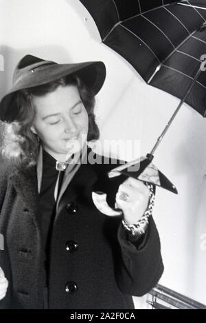 Ein Besucherin der Wiener Modewoche, im Haus der Mode ' palais Lobkowitz', bei einer von Päsentation Regenschirmen, 1940er Jahre Deutschland. Un visiteur de la fashion week de Vienne, dans la chambre de la mode ' palais Lobkowitz', lors d'une présentation de parapluies, l'Allemagne des années 40. Banque D'Images