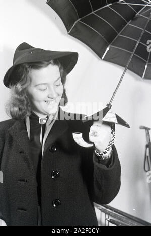 Ein Besucherin der Wiener Modewoche, im Haus der Mode ' palais Lobkowitz', bei einer von Päsentation Regenschirmen, 1940er Jahre Deutschland. Un visiteur de la fashion week de Vienne, dans la chambre de la mode ' palais Lobkowitz', lors d'une présentation de parapluies, l'Allemagne des années 40. Banque D'Images