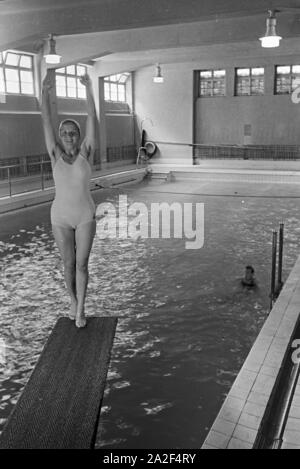 Junge Frau auf dem Sprungturm im Schwimmbad, Freudenstadt, Deutschland 1930 er Jahre. Jeune femme debout sur la tour de plongée dans une piscine, Freudenstadt, Allemagne 1930. Banque D'Images
