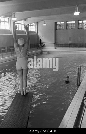 Junge Frau auf dem Sprungturm im Schwimmbad, Freudenstadt, Deutschland 1930 er Jahre. Jeune femme debout sur la tour de plongée dans une piscine, Freudenstadt, Allemagne 1930. Banque D'Images