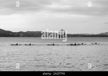 Un groupe de kayakistes en passant en face du gros AHTS anchor handling tug supply Skandi navire à Iceman Byfjorden, Bergen, Norvège Banque D'Images