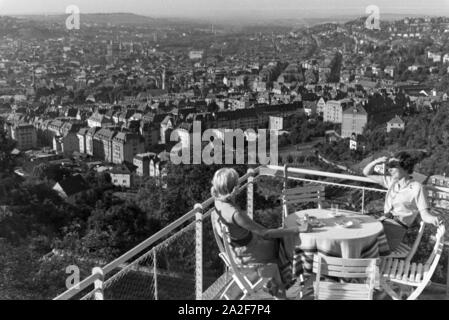 Zwei junge Frauen genießen von der Caféterrasse aus den Blick über Stuttgart, Deutschland 1930 er Jahre. Deux jeunes femmes profitez de la vue sur Stuttgart à partir de la terrasse d'un café, de l'Allemagne des années 1930. Banque D'Images