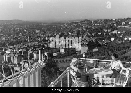 Zwei junge Frauen genießen von der Caféterrasse aus den Blick über Stuttgart, Deutschland 1930 er Jahre. Deux jeunes femmes profitez de la vue sur Stuttgart à partir de la terrasse d'un café, de l'Allemagne des années 1930. Banque D'Images