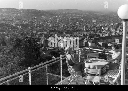 Zwei junge Frauen genießen von der Caféterrasse aus den Blick über Stuttgart, Deutschland 1930 er Jahre. Deux jeunes femmes profitez de la vue sur Stuttgart à partir de la terrasse d'un café, de l'Allemagne des années 1930. Banque D'Images