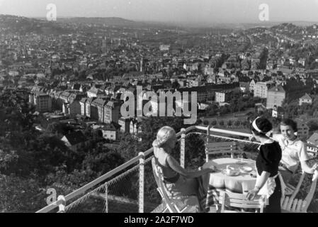 Zwei junge Frauen genießen von der Caféterrasse aus den Blick über Stuttgart, Deutschland 1930 er Jahre. Deux jeunes femmes profitez de la vue sur Stuttgart à partir de la terrasse d'un café, de l'Allemagne des années 1930. Banque D'Images