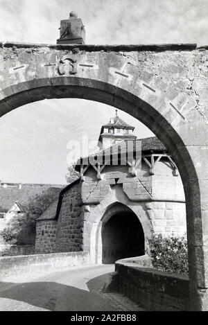 Blick durch einen Torbogen auf die historischen Bauwerke à Rothenburg ob der Tauber, Allemagne Allemagne Années 1930 er Jahre. Vue à travers une arche sur les bâtiments historiques de Rothenburg ob der Tauber, Allemagne 1930. Banque D'Images